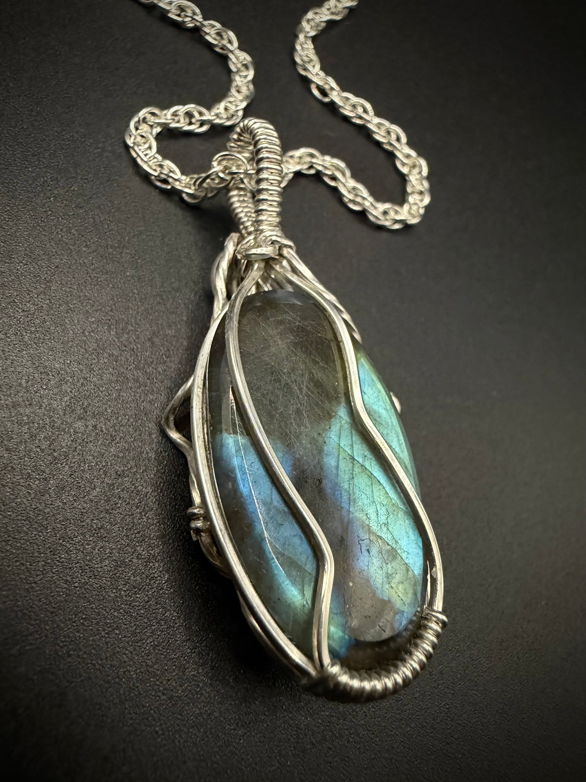 Back view of the handcrafted sterling silver Calypso Pendant showing the intricate wire woven structure holding the labradorite stone.