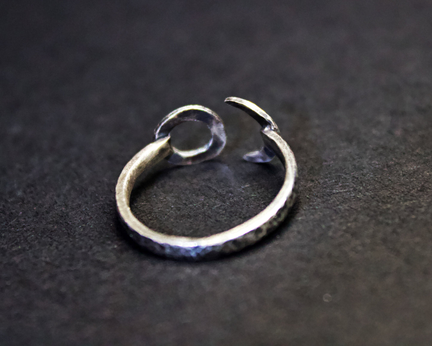 Silver ring with a unique design on a dark background