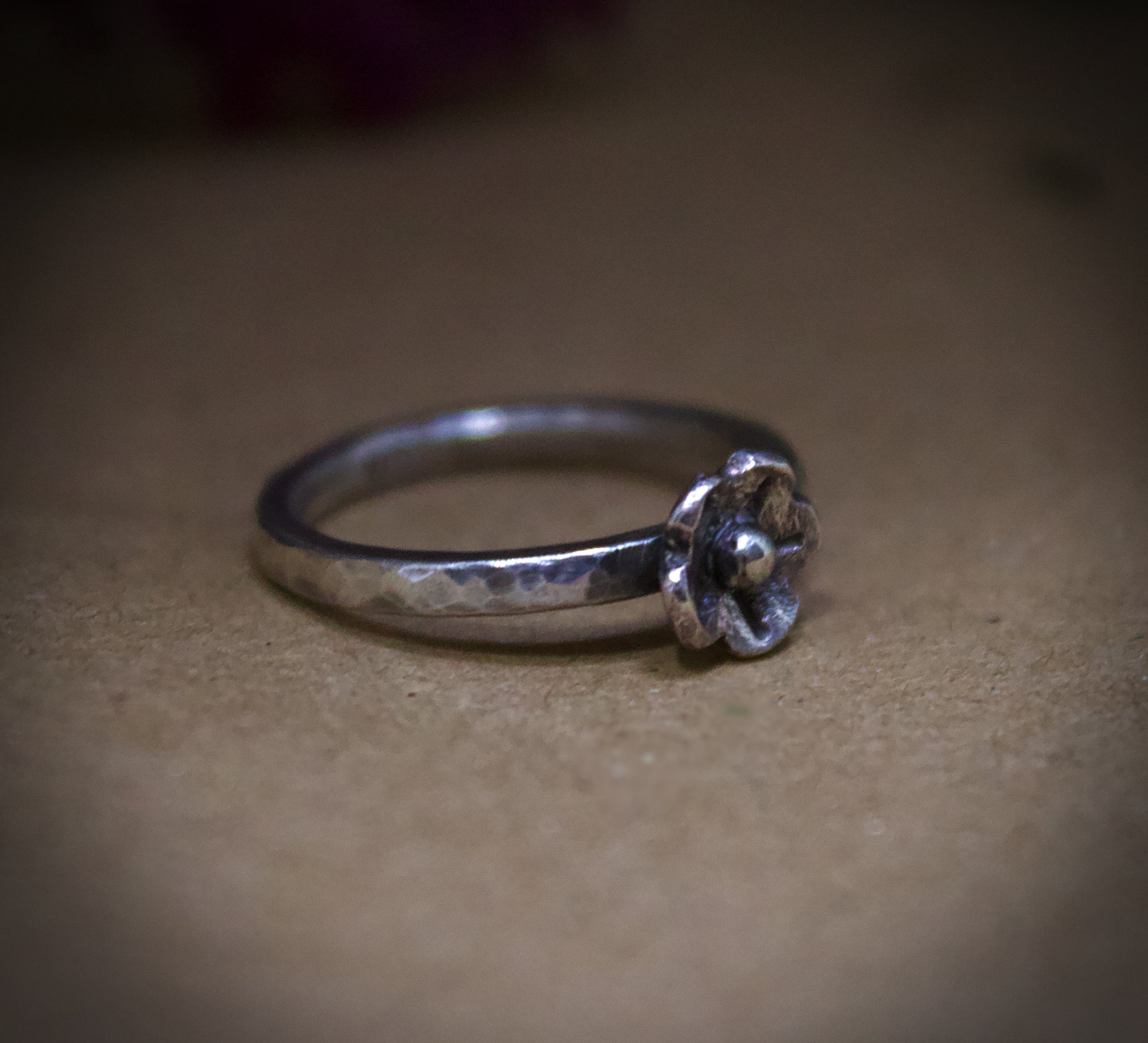 Silver ring with a floral design on a beige background