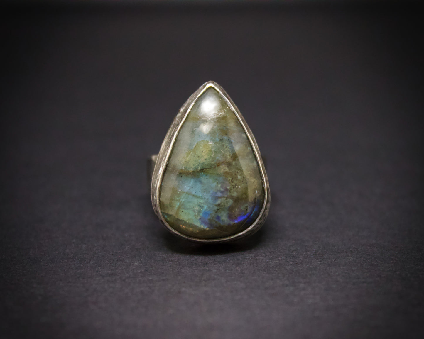 Teardrop-shaped gemstone ring on a dark background