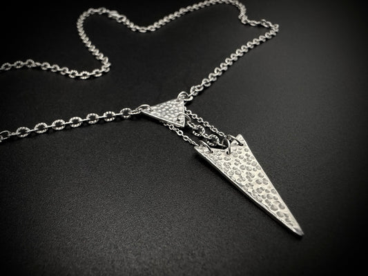 Silver necklace with a unique pendant on a dark background