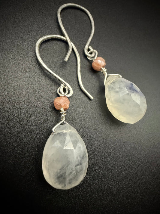 Handmade Lotus Drops earrings featuring large faceted white moonstone teardrops and small peach moonstone accent beads on sterling silver wires.