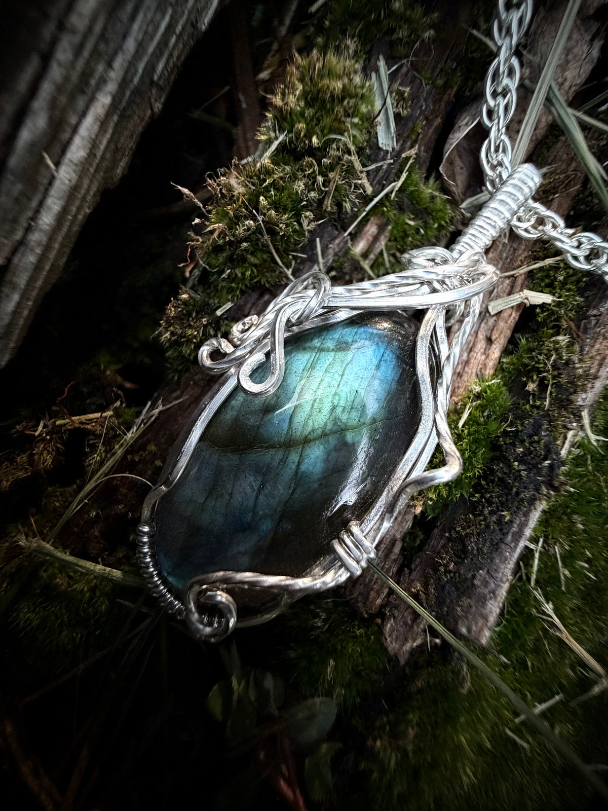 Handcrafted sterling silver Calypso Pendant featuring a blue-green labradorite stone wrapped in vine-like silver wirework.