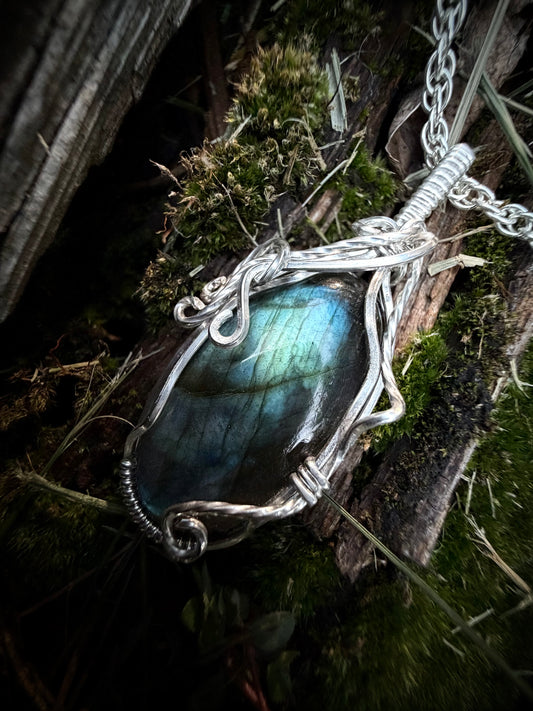 Handcrafted sterling silver Calypso Pendant featuring a blue-green labradorite stone wrapped in vine-like silver wirework.