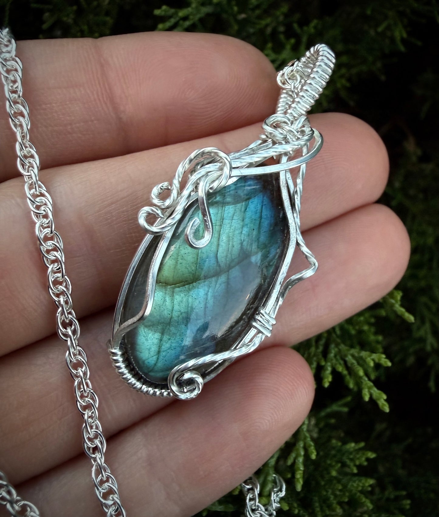Close-up of the Calypso Pendant showing the blue-green flash of the labradorite stone and intricate silver vine wirework.