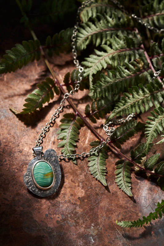 Necklace with a pendant on a leafy background