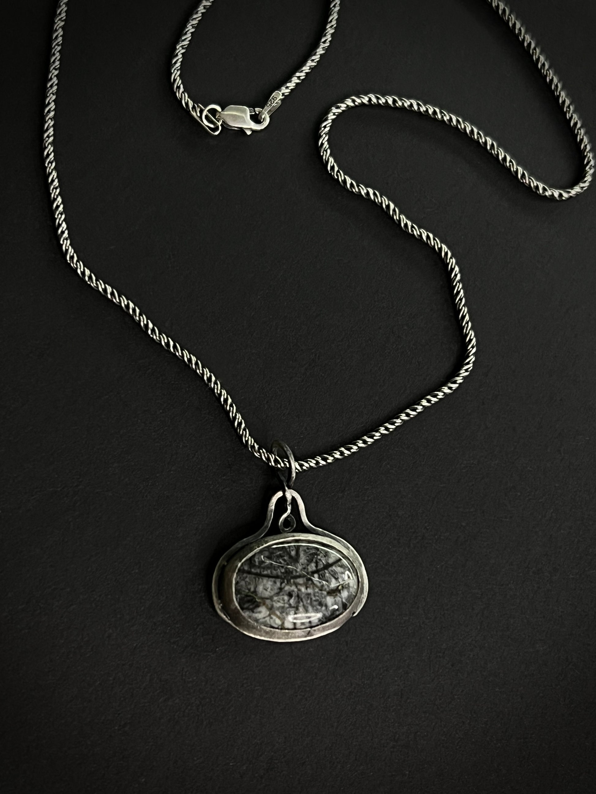 Handcrafted Picasso Jasper pendant with charcoal and silver-grey brushstroke patterns, set in a sterling silver bezel on a delicate chain.