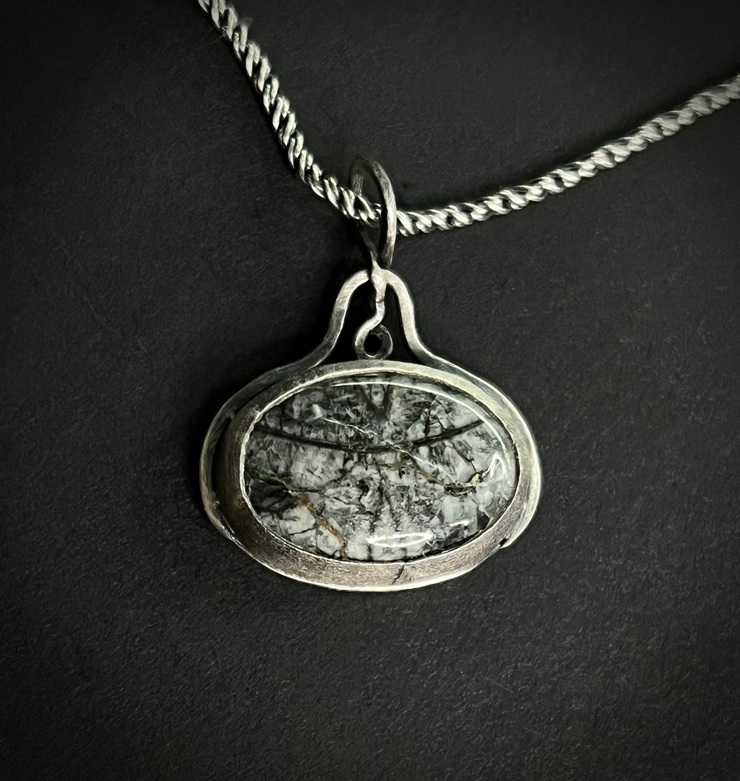 Close-up of the Liath Pendant featuring Picasso Jasper with black and grey brushstroke patterns in a handcrafted silver setting.