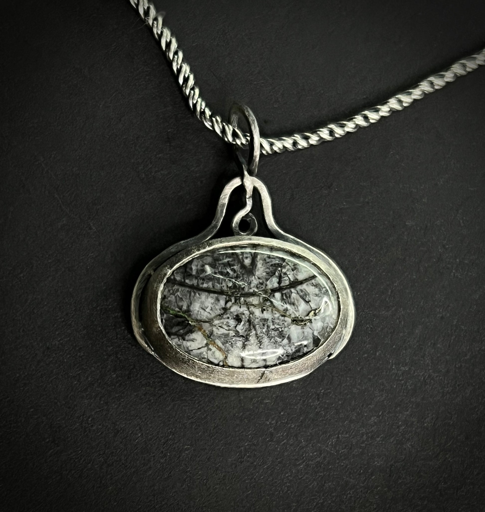 Close-up of the Liath Pendant featuring Picasso Jasper with black and grey brushstroke patterns in a handcrafted silver setting.