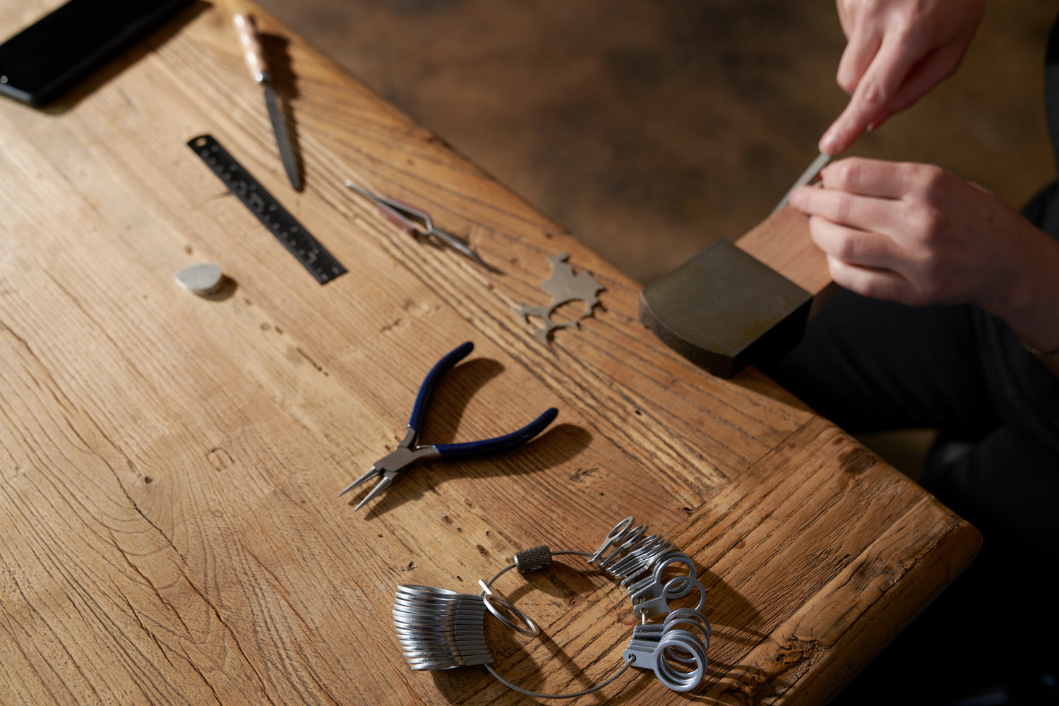 Person working with tools on a wooden surface